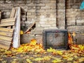Old Broken TV Set Covered In Dirt With Small Red Heart Standing Outdoors In Yellow Autumn Maple Leaves Near Brick Wall