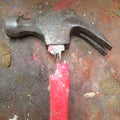 Old broken hammer with red fibreglass handle on a stained grungy Royalty Free Stock Photo