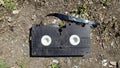 An old broken video cassette abandoned on the ground. Royalty Free Stock Photo