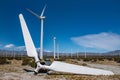 Old broken wind turbine blade in field of wind turbines