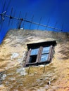 Old broken window with antenna and blue sky an abandoned house in Bakar,Croatia Royalty Free Stock Photo