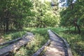 Old and broken wooden plank pathway walkway in green summer forest Royalty Free Stock Photo