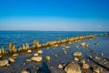 Wooden posts covered in seaweed and rocks in sea Royalty Free Stock Photo