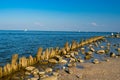 Wooden posts covered in seaweed and rocks in sea Royalty Free Stock Photo