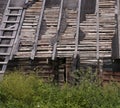 Old broken wooden roof of rural building with logs and planks