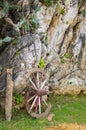 An old broken wooden wheel of wagon leaning up against a stone wall Royalty Free Stock Photo