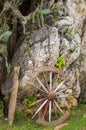 An old broken wooden wheel of wagon leaning up against a stone wall Royalty Free Stock Photo