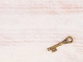 Old bronze antique key on light brown wooden background Royalty Free Stock Photo