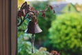 Old bronze bell on a house on a background of garden at summer. Royalty Free Stock Photo