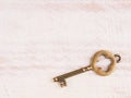 Old bronze key on light brown wooden background Royalty Free Stock Photo