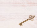 Old bronze key on light brown wooden background Royalty Free Stock Photo