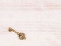 Old bronze key on light brown wooden background Royalty Free Stock Photo