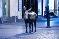 Old bronze sculpture of a donkey on the street in the historical district of Torun