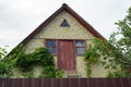 Old brown brick attic of a rural house with a red wooden door Royalty Free Stock Photo