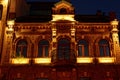 old brown brick house with windows and a balcony with lighting on the night street Royalty Free Stock Photo