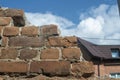 Old brown brick wall against the blue sky. Royalty Free Stock Photo