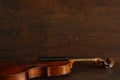 Old brown broken violin without strings lies on brown antique wood background