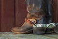 Old brown cowboy boots with spurs on a wood surface in sunlight Royalty Free Stock Photo