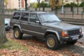 Old brown grey veteran offroad 4x4 retro Jeep Grand Cherokee high suspension parked