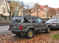 Old brown grey veteran offroad 4x4 retro Jeep Grand Cherokee high suspension parked