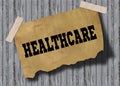 Old brown paper with HEALTHCARE text on wooden background.