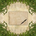 Old brown paper and pen on Green creeper plant on wall for text Royalty Free Stock Photo