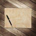 Old brown paper and pen on wooden wall background for texture Royalty Free Stock Photo