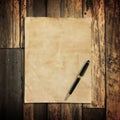 Old brown paper and pen on wooden Royalty Free Stock Photo