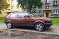Old brown popular veteran compact car Volkswagen Golf 2 parked on pave stones