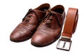 Old brown shoes and brown belt on an isolated white background Royalty Free Stock Photo