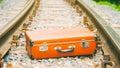 Old brown suitcase on the railway