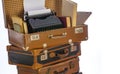 Old brown suitcases with old retro typing machine on white background