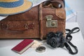 Old brown vintage suitcase with straw hat, photo camera, sunglasses, passport and a map, travel and summer vacation concept, copy Royalty Free Stock Photo