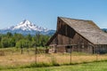 Old Brown Wooden Barn on a ranch and Mt. Hood in Oregon in the background. Royalty Free Stock Photo