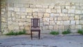 An old, wooden chair on the street.