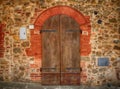 Old brown wooden door in ancient house, Italy. Royalty Free Stock Photo