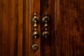 Old brown wooden door with antique handles, detail of a door. Metal knocker on a door Royalty Free Stock Photo