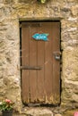 An old shabby brown door with a beach sign. Royalty Free Stock Photo