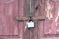The old brown wooden door is locked with a lock. Royalty Free Stock Photo