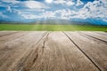 Wooden floor beside green rice field with blue sky and sun shines in the day Royalty Free Stock Photo