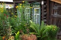 Old brown wooden house with green yellow white carved window frames and flowers in front garden Royalty Free Stock Photo