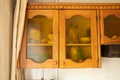 Old brown wooden kitchen cabinet with glass doors in the kitchen at home, kitchen furniture Royalty Free Stock Photo