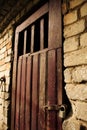 Old brown wooden door in white brick wall