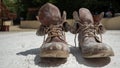 Old brown work boots covered in concrete