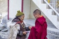 Old Buddhist woman and monk on the street next to the monastery Lamayuru in Ladakh, North India Royalty Free Stock Photo