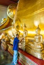 Old Buddist man gilding onthe knee of golden Buddha image Royalty Free Stock Photo