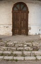 An old building with an arched wooden door and a stone ruined staircase Royalty Free Stock Photo