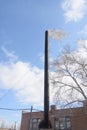 Old building is boiler room. Black large chimney with dark smoke against blue sky. Environmental pollution concept, ecology Royalty Free Stock Photo