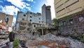 Old building with old chalk bricks demolished manually in front of modern skyscrapers in Port-Louis Mauritius Royalty Free Stock Photo