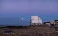 Old building at coast of Sidi Kaouki, Morocco, Africa. Moon in the evening sky. Sunset time. morocco`s wonderfull surf to Royalty Free Stock Photo